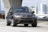 Driving 2013 BMW X5 xDrive50i in Sparkling Bronze Metallic from a front right view